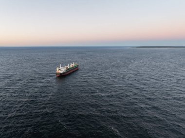 Sakin Baltık Denizi 'nde gün batımında yelken açan büyük bir kargo gemisinin hava görüntüsü..