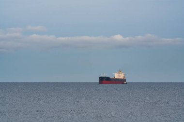 Bulk taşıyıcı kargo gemisi, sakin Baltık Denizi sularında, Estonya açıklarında, açık bulutlu, engin, sakin, mavi bir gökyüzünün altında yol alıyor..