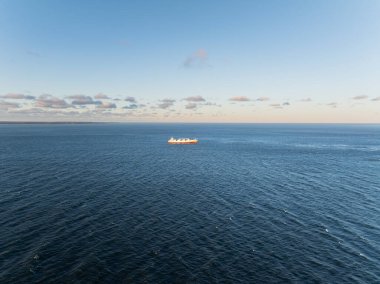 Gün batımında açık bir gökyüzünün altında mavi Baltık Denizi 'nde seyreden bir Rus kargo gemisinin insansız hava aracı görüntüsü..