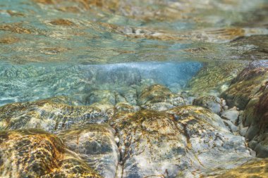 Akdeniz 'in kristal berraklığında turkuaz suları Fransız kıyıları yakınlarında güneş altında kayalar ve kabarcıklar gösteriyor..