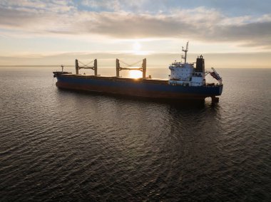 Soğuk bir kış günbatımında Baltık Denizi 'ne demir atmış büyük bir sanayi gemisinin insansız hava aracı görüntüsü..