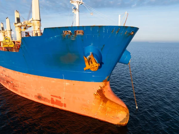 Estonya kıyısı yakınlarındaki Baltık Denizi 'nde demirlemiş büyük bir kargo gemisi. Demir zincirli bir sanayi gemisi pruvası görünüyor..