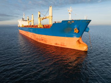 Sakin bir kış günü Baltık Denizi 'nde demirlemiş büyük, boş bir yük gemisinin insansız hava aracı görüntüsü.