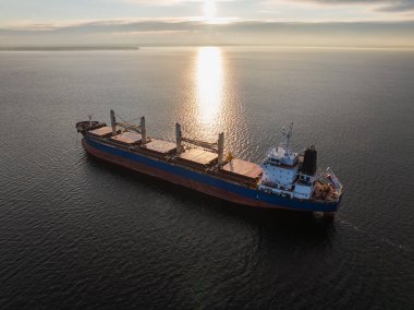 Kışın günbatımında sakin Baltık Denizi 'nde yelken açan büyük, boş bir gemi insansız hava aracı görüntüsü..