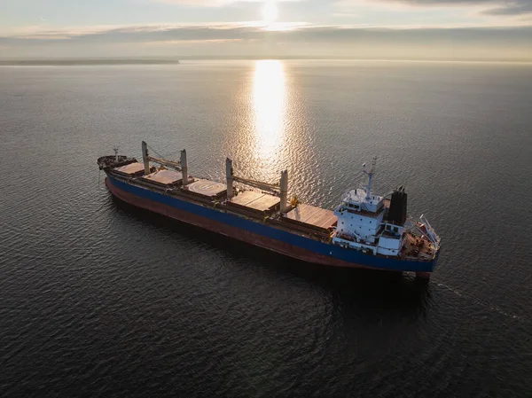 Kışın günbatımında sakin Baltık Denizi 'nde yelken açan büyük, boş bir gemi insansız hava aracı görüntüsü..