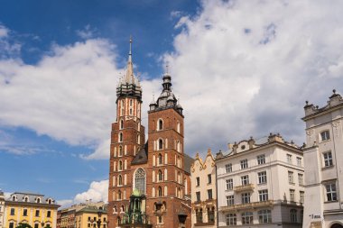 KRAKOW, POLAND - 28 Temmuz 2023: St. Mary Bazilikası 'nın dış görünümü ve Ana Pazar Meydanı' ndaki tarihi binalar.
