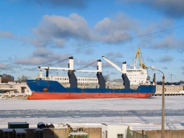 Büyük mavi ve kırmızı kargo gemisi, aydınlık bir kış günü Estonya 'nın Kopli, Tallinn limanına yanaştı..