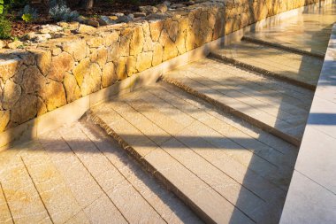 Yazın Akdeniz 'in parlak güneşi altında Monako parkında taş basamaklı bir çeşme ile modern lüks su özelliği.