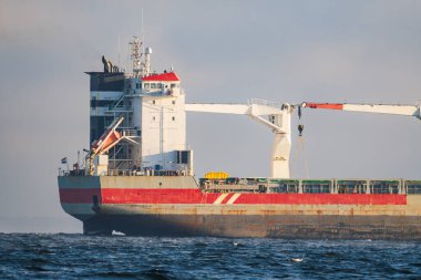 Altın saat boyunca, köprü, radar direği ve vinç ile Baltık Denizi 'ne bakan bir kargo gemisinin detaylı görüntüsü..