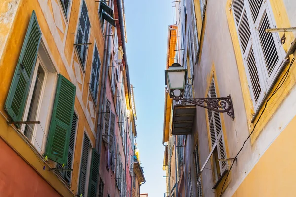Eski şehrin güzel dar sokakları Güzel Fransa Renkli sarı turuncu binalar Yeşil kepenkler klasik lamba ve açık mavi gökyüzü.