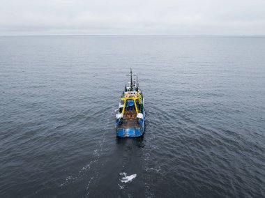 Baltık Denizi 'nin soğuk sularında yüzen profesyonel mavi balıkçı teknesinin yüksek açılı görüntüsü..