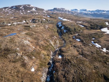 Dar kayalık bir kanyonun yüksek açılı drone görüntüsü. Norveç 'in vahşi dağ tundralarından akan bir nehir..
