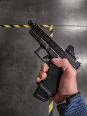 BALTIC STATES 4 Mart 2026 Bir Glock 19 Gen 5 x19mm tabanca Bir Olight taktik el feneri ile donatılmış ve üç adet 9 mm 'lik sert plastik bir çantada kırmızı nokta görüşü sergilenmektedir.