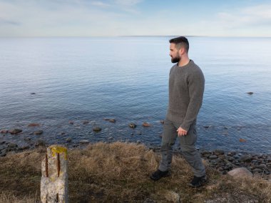 Uçurumun kenarında duran sakallı, düşünceli bir adam. Baltık Denizi 'ne bakıyor. Havadan bakıyor..