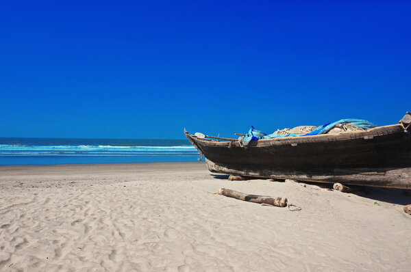 Small wooden boat on caribbean beach in goa