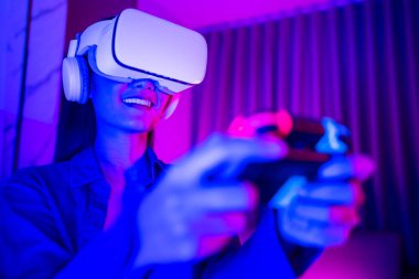 Genç Asyalı kadın sanal gerçeklik kulaklığı kullanıyor. Neon light stüdyo portresi. Sanal gerçeklik, simülasyon, oyun ve geleceğin teknolojisi kavramı..