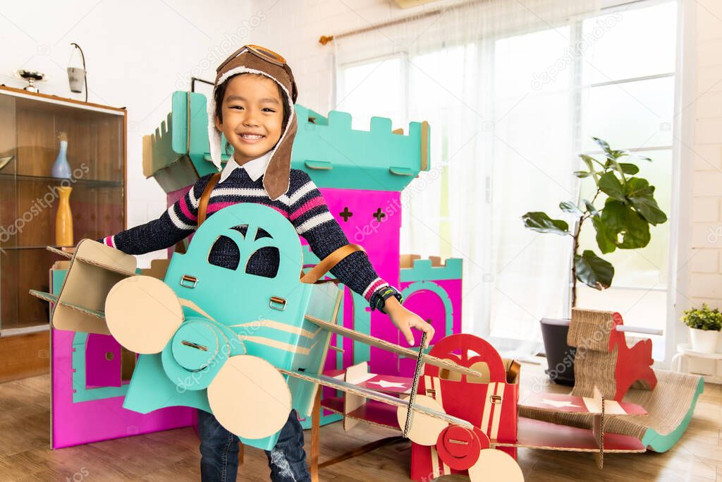 Cute kids playing while parents relaxing at home together, smiling active boy entertaining with paper toy,rocking horse , happy family spending time together in living room on weekend.Asian family happy time concept.