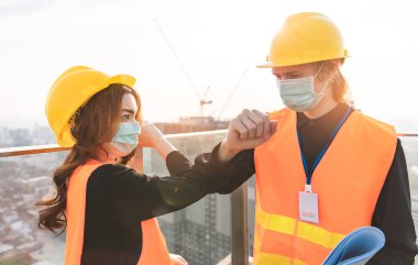 Mekanik fabrika okuma talimatları mühendisleri gülümseyen imalatçı kadın ve erkek, beyaz gökyüzü ve bina kulesinin arka planına güvenerek ayakta duruyorlar. Sanatsal geçmişi parlak insanları yetiştirme sanayisi.