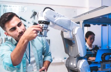 Erkek Mühendisler Bakım Robotu Kolu Laboratuvarda. Modern ekipmanlarla Yüksek Teknoloji Araştırma Laboratuvarı 'nda. Teknoloji ve Yenilik Konsepti. Profesyonel Japon Geliştirme Mühendisi Yapay Zeka Testi yapıyor. Konsepti başlat.