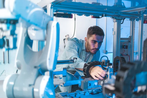 Laboratuvarda Asyalı Mühendisler Bakım Robot Kolu ile buluşacağım. Modern ekipmanlarla Yüksek Teknoloji Araştırma Laboratuvarındalar. Teknoloji ve Yenilik Konsepti. Profesyonel Japon Geliştirme Mühendisi Bir Yapay Zeka Testi Yapıyor.