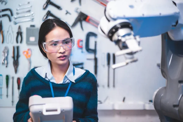 Female Engineers Maintenance Robot Arm at Lab. She are in a High Tech Research Laboratory with Modern Equipment. Technology and Innovation Concept.Professional Japanese Development Engineer is Testing an Artificial Intelligence.start up concept.