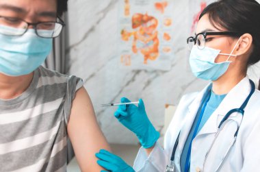 Aşı, aşı, hastalık önleme konsepti. Tıbbi maske takan insanlar Covid-19 ya da grip aşısı yaptırıyorlar. Profesyonel hemşire ya da doktor hastaya antiviral iğne yapıyor..