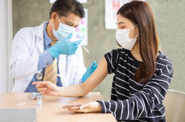 Genç hastaya kıdemli doktor şırıngası. Hastaneye maske takın. Sağlık sigortası konsepti..