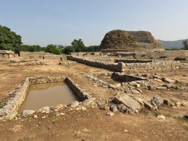 Buddhist ruins of Dharmarajika Stupa with pond and small stupas in Taxila