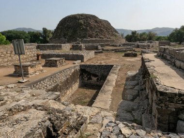 Dharmarajika complex view of small stupas beside sacred pond with main great stupa reflecting buddhist devotion in taxila pakistan