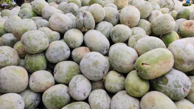 İslamabad pazarında yere dizilmiş büyük kül kabakları yerel hasatı ve kırsal ticareti gösteriyor.