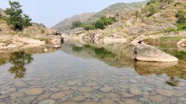 Soan Nehri 'nin huzurlu akışı kristal berrak suyla doğal güneş ışığı altında yuvarlak taşlar ortaya çıkarıyor.