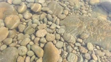 Kristal berrak suyun makro görüntüsü yumuşak hareket ve güneş ışığı doğal akışında parıldıyor