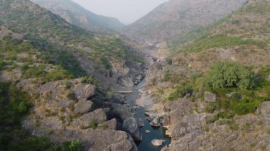 Güneş ışığı altında yüksek dağların arasında kıvrılan Soan Nehri