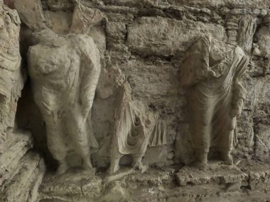Heritage Buddhist stupa carvings showing ceremonial figures in draped garments Mohra Muradu Taxila Pakistan
