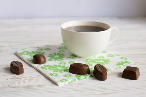 Chocolade snoepjes en een kopje koffie — Stockfoto