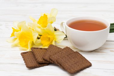 Fincan çay, kurabiye ve Nergis