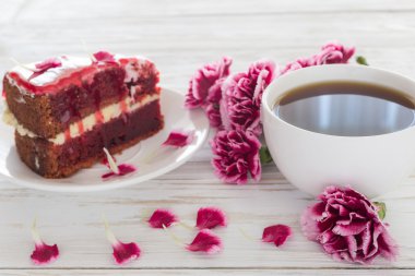 Kırmızı kadife kek, fincan kahve ve pembe karanfil 