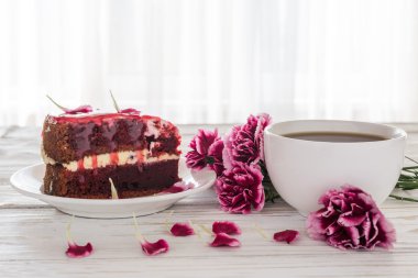 Kırmızı kadife kek, fincan kahve ve pembe karanfil 