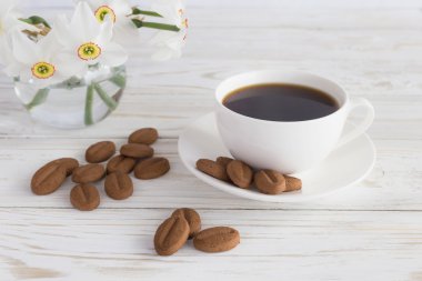 Fincan kahve, kurabiye ve Nergis Beyaz ahşap zemin üzerinde