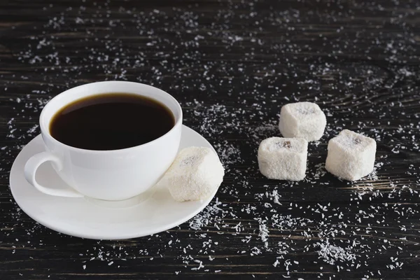 Tasse Kaffee und Rahat Lokum mit Kokosnuss auf schwarzem Holzrücken — Stockfoto