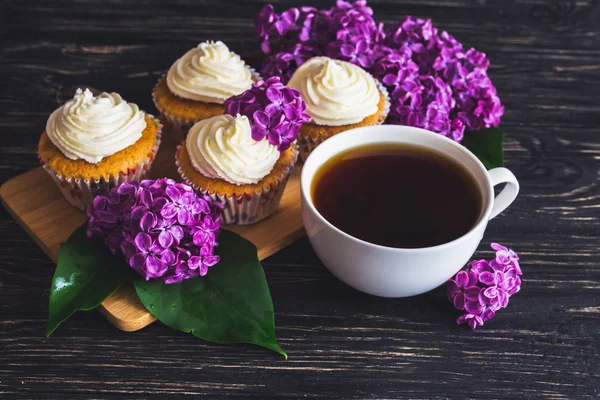 Cupcakes with cream, coffee and flowers