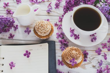 Krem, kahve, defter ve çiçekler ile cupcakes