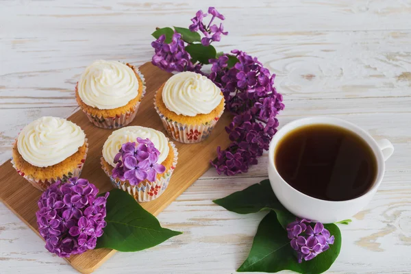 Кекси з вершками, кавою та квітами — стокове фото