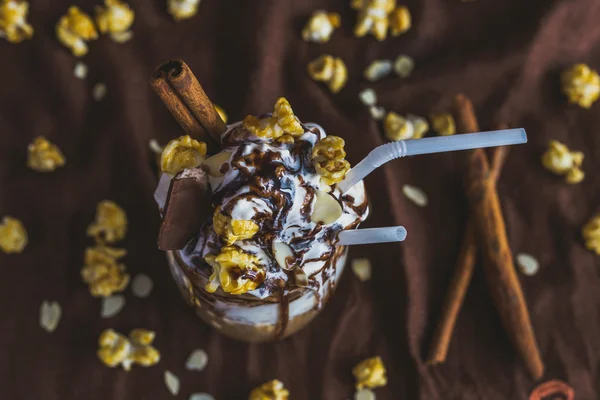 Vaso de café con crema agria, palomitas de caramelo y chocolate — Foto de Stock