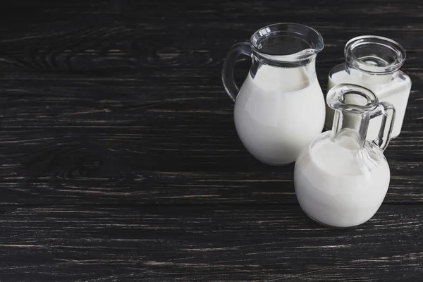 Milk jars on wooden background — Stock Photo, Image
