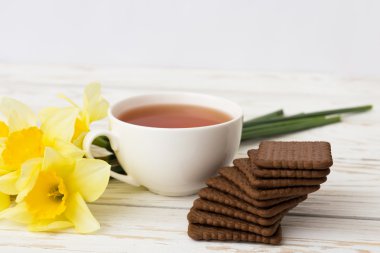 Fincan çay, kurabiye ve Nergis