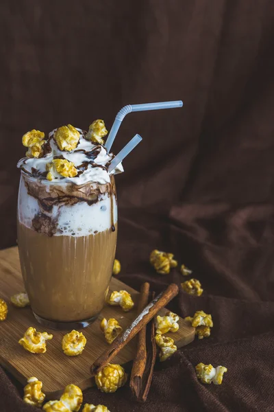 Glas kaffe med gräddfil, karamell popcorn och choklad — Stockfoto