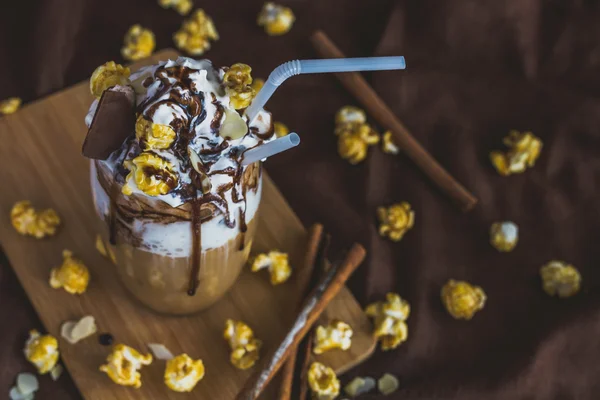 Vaso de café con crema agria, palomitas de caramelo y chocolate — Foto de Stock