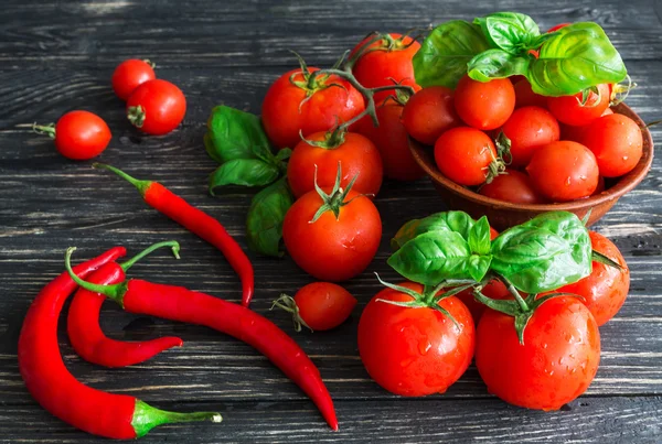 Tomaten op vine, rode peper en groene basilicum — Stockfoto