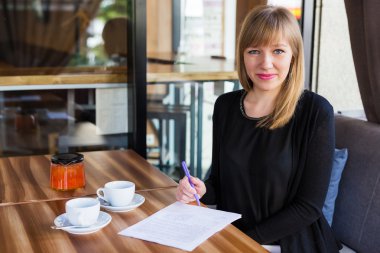 çay içme ve iş kağıtları ile çalışan kadın